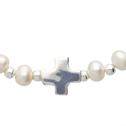 Pulsera elástica con perla y casquilla y dije de cruz en plata .925